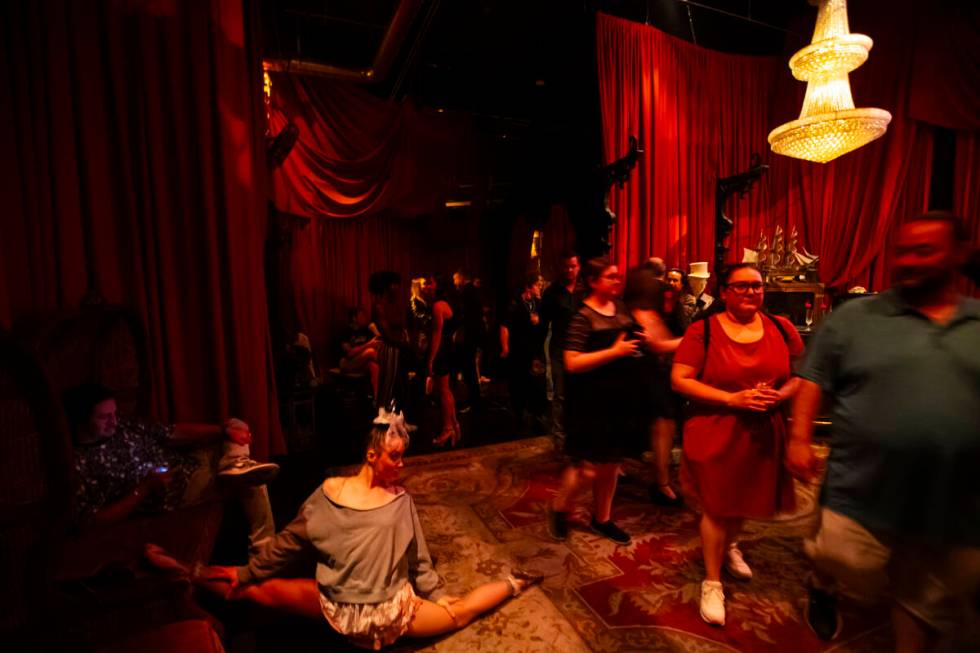 Contortionist and aerialist Cheryl Birch, left, stretches as guests walk by during the closing ...