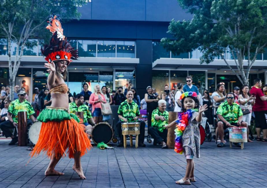 Performer Leina’ala Cardona, with Hot Lava Productions, shows Nevaeh Garcia, 3, how to dance ...