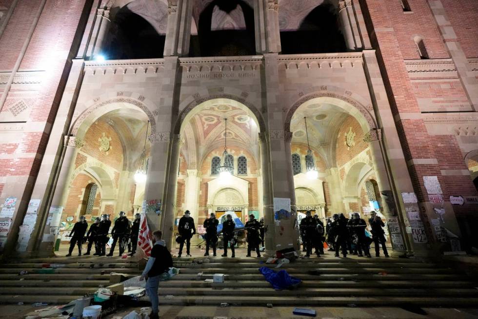 Police stand outside a building after raiding a pro-Palestinian encampment on the UCLA campus, ...