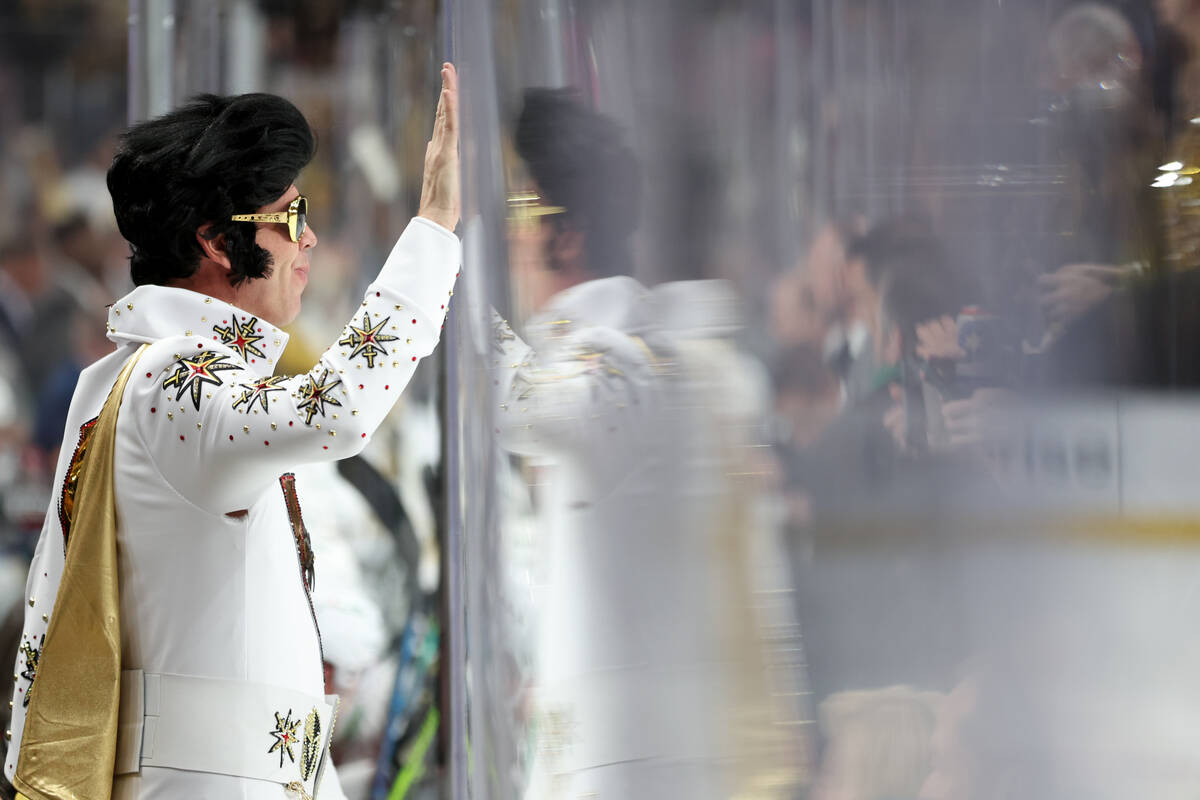 A Golden Knights dressed as Elvis slams the boards after the Knights scored during the third pe ...