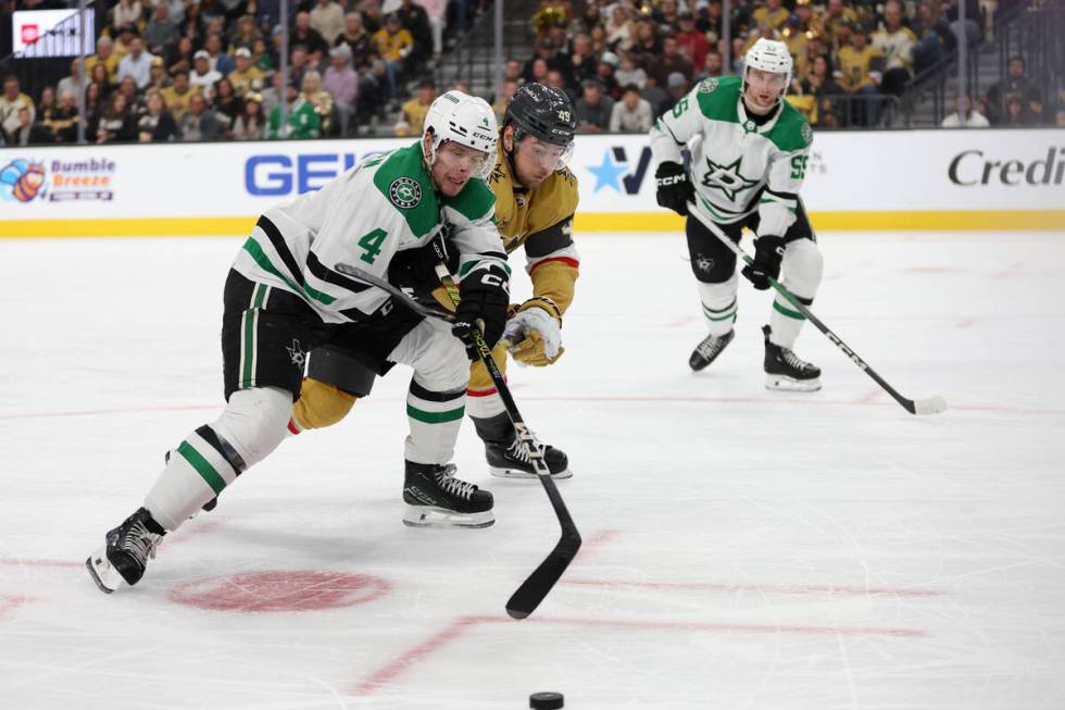 Golden Knights center Ivan Barbashev (49) and Stars defenseman Miro Heiskanen (4) struggle towa ...