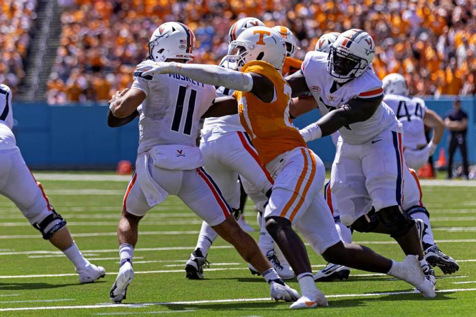 Virginia quarterback Tony Muskett (11) is pressured by Tennessee defensive lineman James Pearce ...