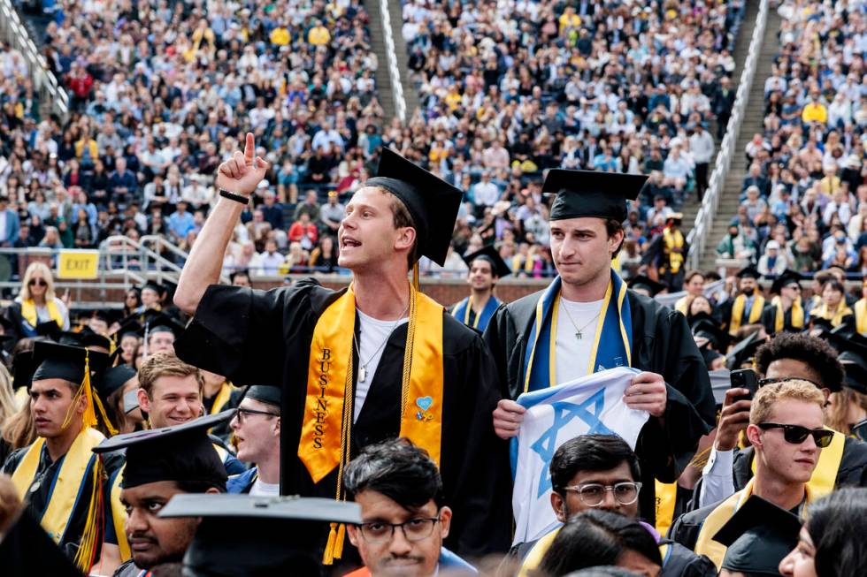 Graduates sporting Israeli flags and pins shout at Pro-Palestinian protesters as they demonstra ...