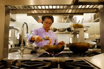 Lotus of Siam owner/chef Saipin Chutima, left, cooks prawns, Friday, July 22, 2022, at her rest ...