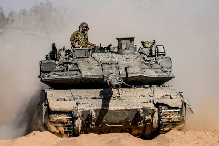 Israeli soldiers drive a tank at a staging ground near the border with the Gaza Strip, in south ...
