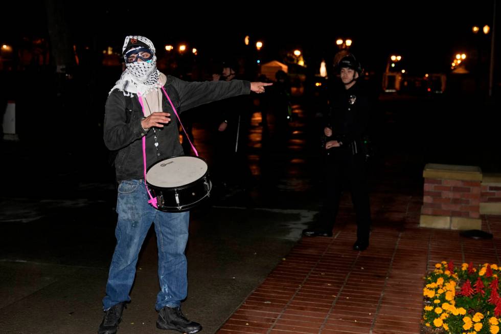 A protestors gestures near police officers after a raid on the pro-Palestinian encampment on th ...