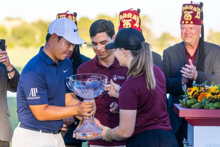 Tom Kim is handed the winning trophy by international patient ambassadors Juan Diego and Gianna ...