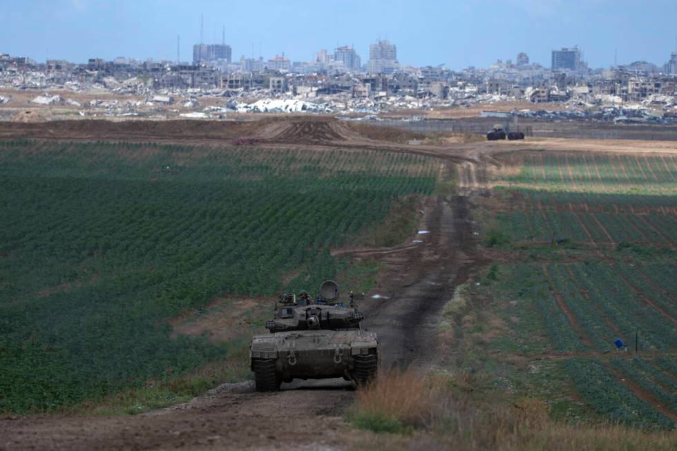 An Israeli Defense Forces tank drives away from the Gaza Strip, as seen from southern Israel, M ...