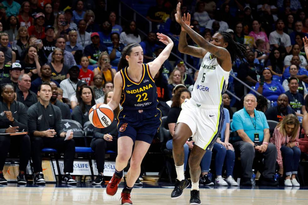 Indiana Fever guard Caitlin Clark (22) drives past Dallas Wings forward Natasha Howard (6) duri ...