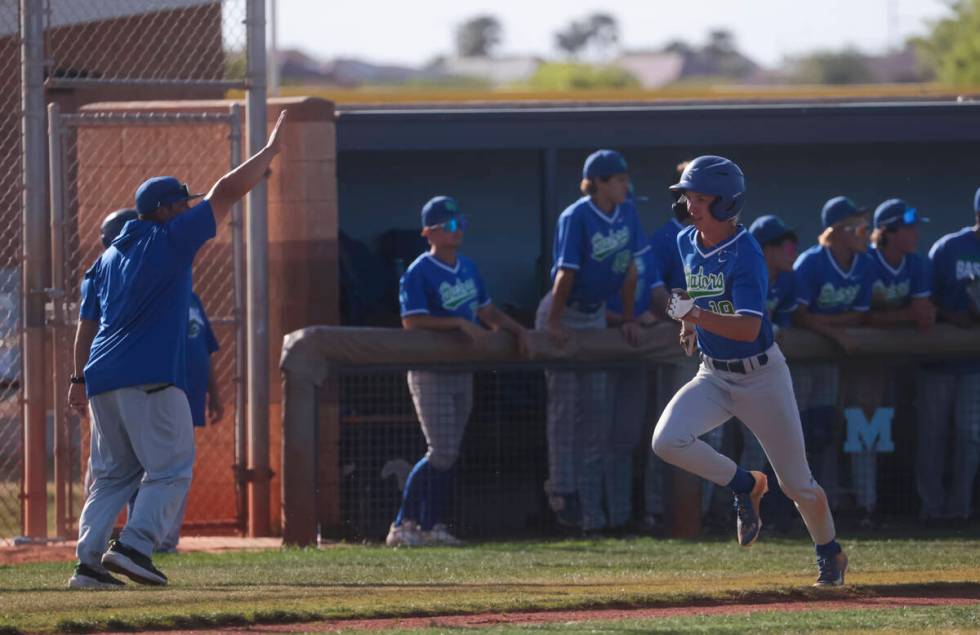 Green Valley's Benjamin Byington runs toward home base to score a run during a high school NIAA ...