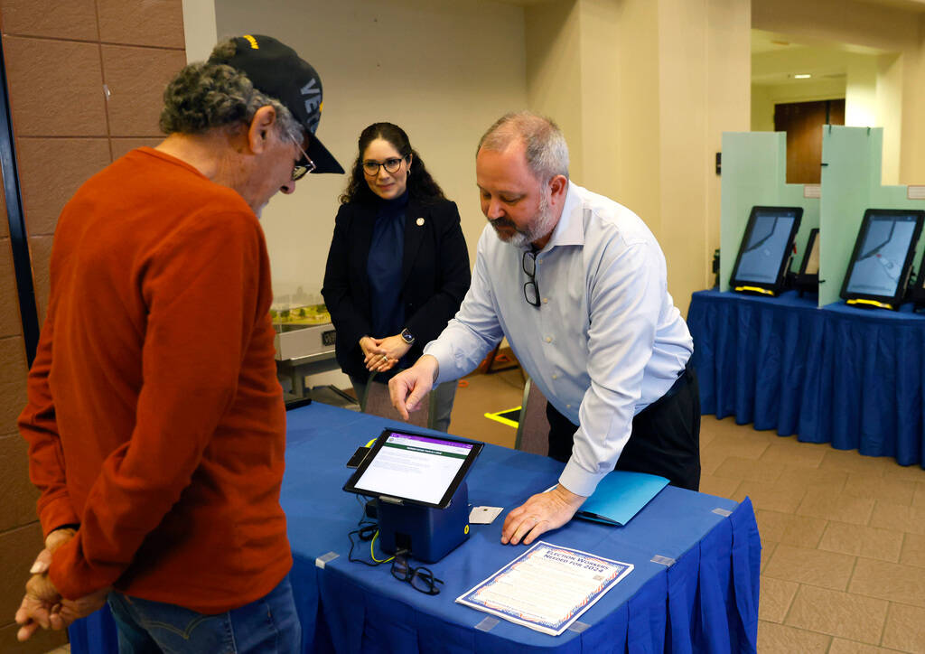 Dan Kulin, right, Clark County's manager of election administration, demonstrates how to regist ...