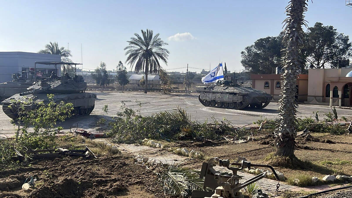 This photo provided by the Israel Defense Forces shows a tank with an Israel flag on it enterin ...