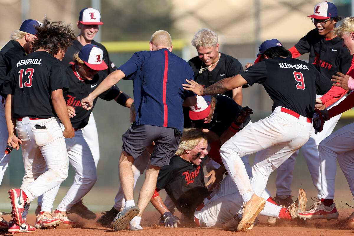 Liberty descends on outfielder Jacob Damore, center, after he hit the game-winning RBI to take ...