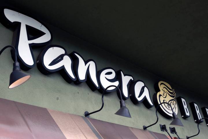 A Panera Bread sign and logo is attached to the outside of a Panera Bread restaurant location i ...