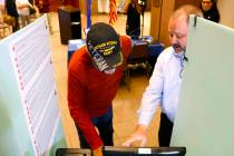 Dan Kulin, right, manager Election Administration, demonstrates how to cast a vote to Pete Pizz ...