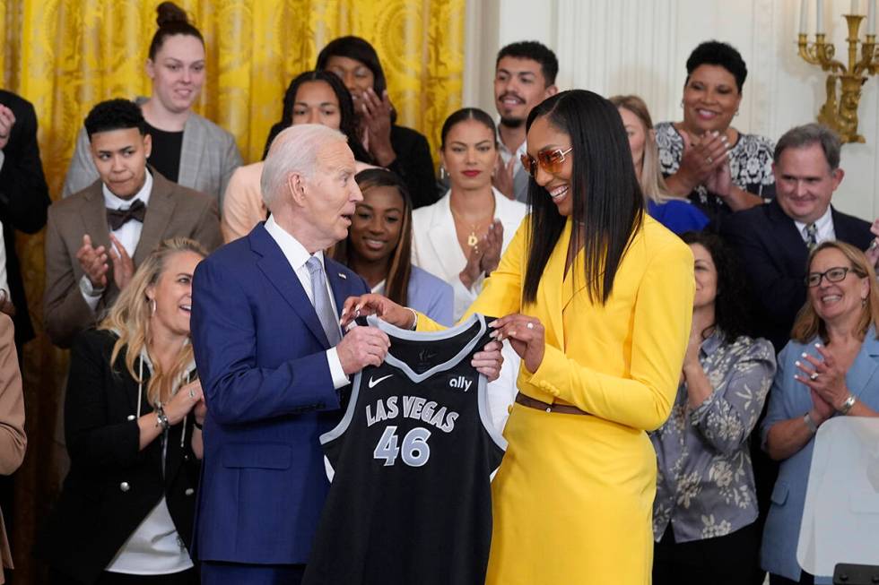 A'ja Wilson, of the WNBA's Las Vegas Aces, right, presents a jersey to President Joe Biden duri ...