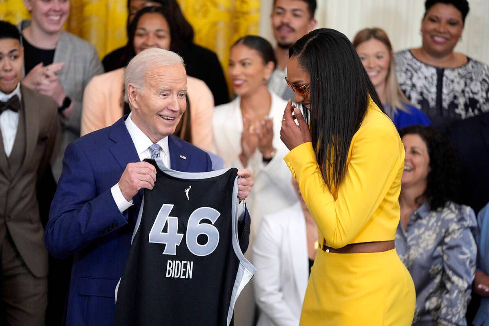 A'ja Wilson, of the WNBA's Las Vegas Aces, right, presents a jersey to President Joe Biden duri ...