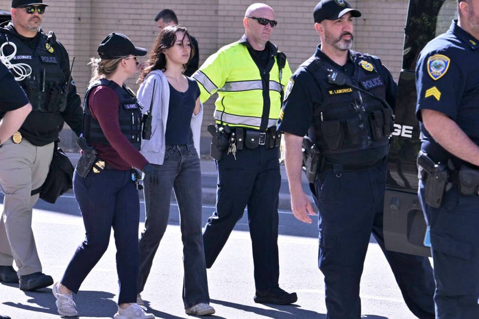 Police detain a pro-Palestinian demonstrator who attempted to block traffic from the garage of ...