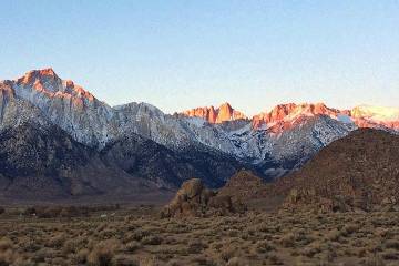 Seen is the eastern Sierra Nevada, with Mt. Whitney, the largest of three pinnacles at center, ...