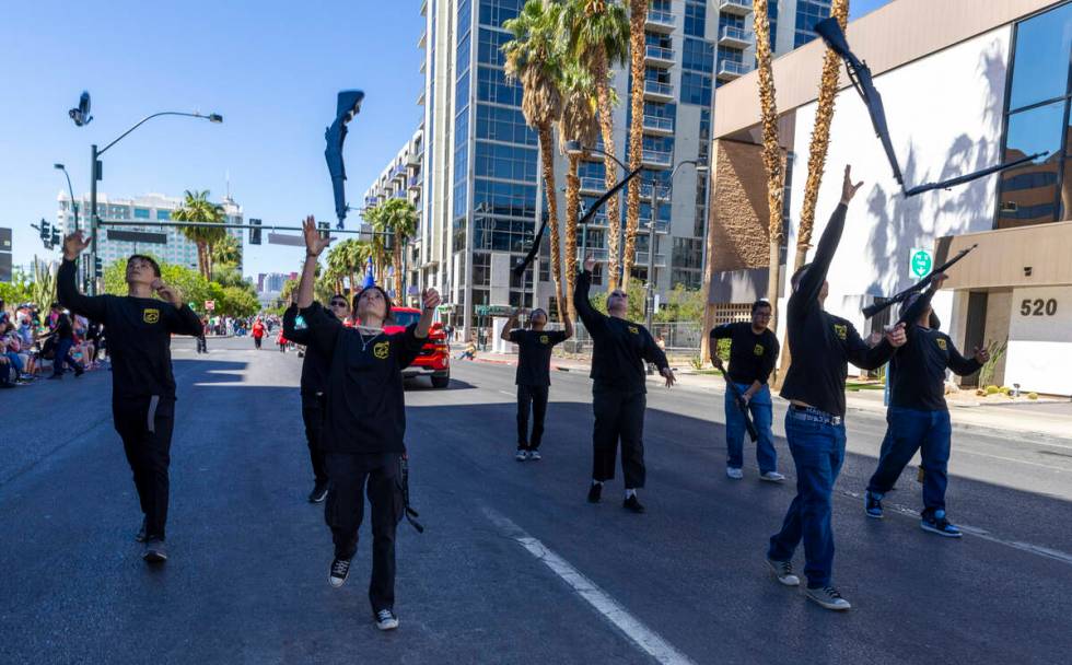 Members of the Sierra Vista High School Army JROTC Drill Team toss their rifles in the air as t ...