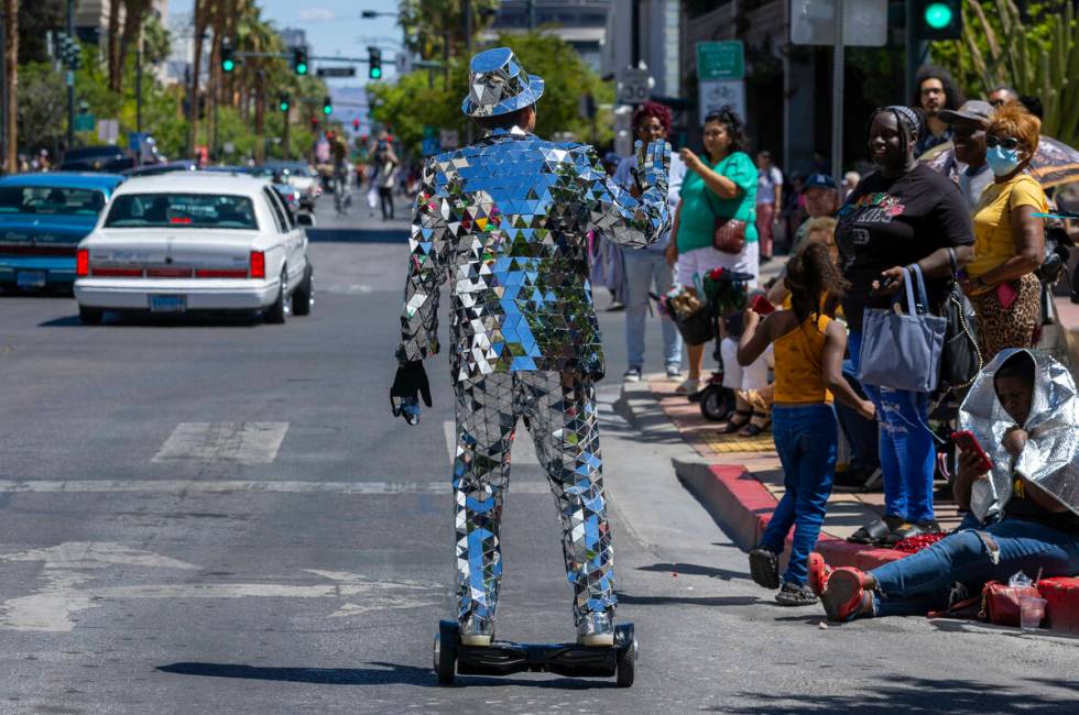 A man in a mirrored suit waves to the the crowd along the route during the Helldorado Parade mo ...