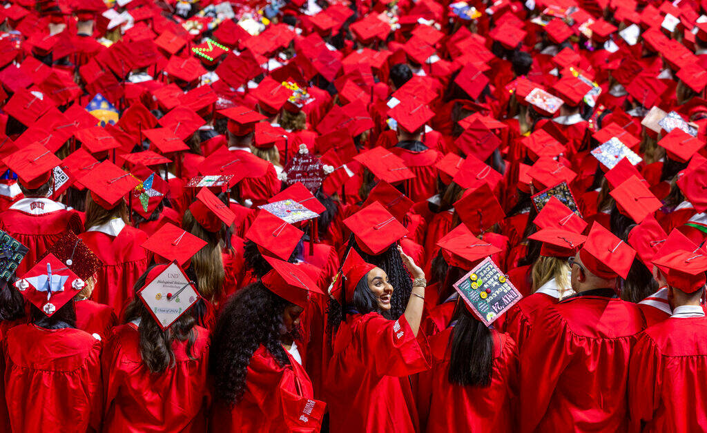 A graduate waves to supporters in the crowd during UNLV spring graduation commencement exercise ...