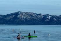 A paddle boarder and a kayaker glide across the surtface of Lake Tahoe's frigid waters on Jan. ...