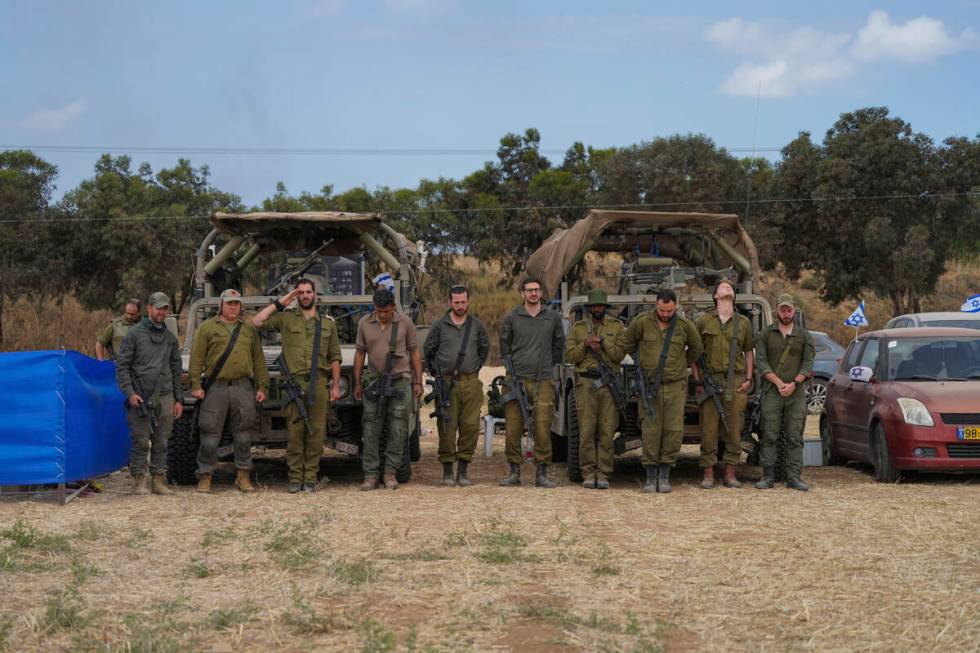 Israeli soldiers stand still as a siren marks the annual Memorial Day for fallen soldiers who d ...