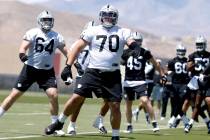 Raiders rookie guard Jackson Powers-Johnson (70) warms up during rookies first day of practice ...