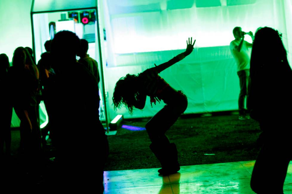 Kiearah Figueroa of Las Vegas, center, dances outside the Sony booth during third night of the ...