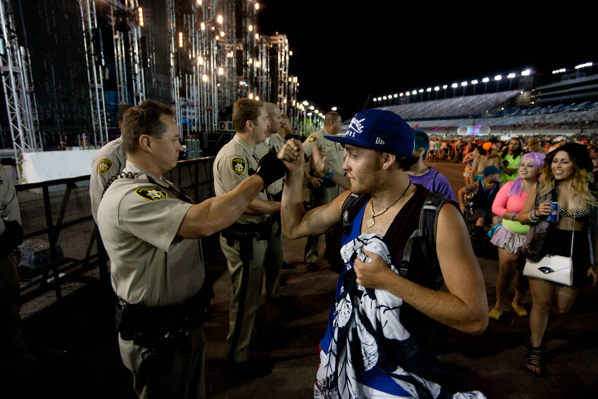 A festival attendee fist-bumps a police officer as the main stages of the Electric Daisy Carniv ...