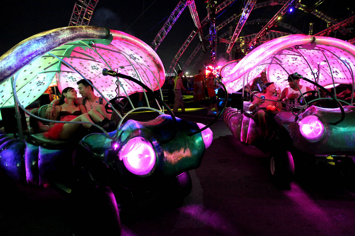 Revelers enjoy parked insect-inspired transportation at the Electric Daisy Carnival at the Las ...