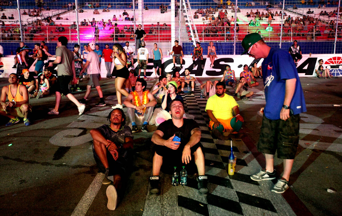 Festival goers relax on the racetrack at the Electric Daisy Carnival at the Las Vegas Motor Spe ...