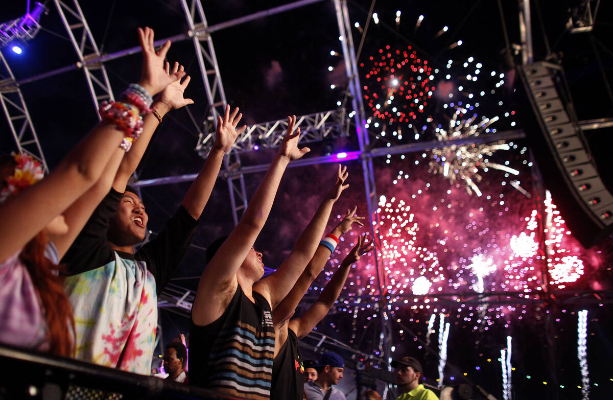 Jaime Yoo, in tie-dyed shirt, dances with others as fireworks erupt over the Electric Daisy Car ...