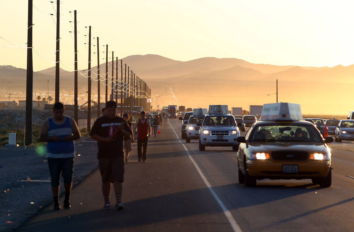 Concert goers troop along a road following the final night of the dusk to dawn Electric Daisy C ...