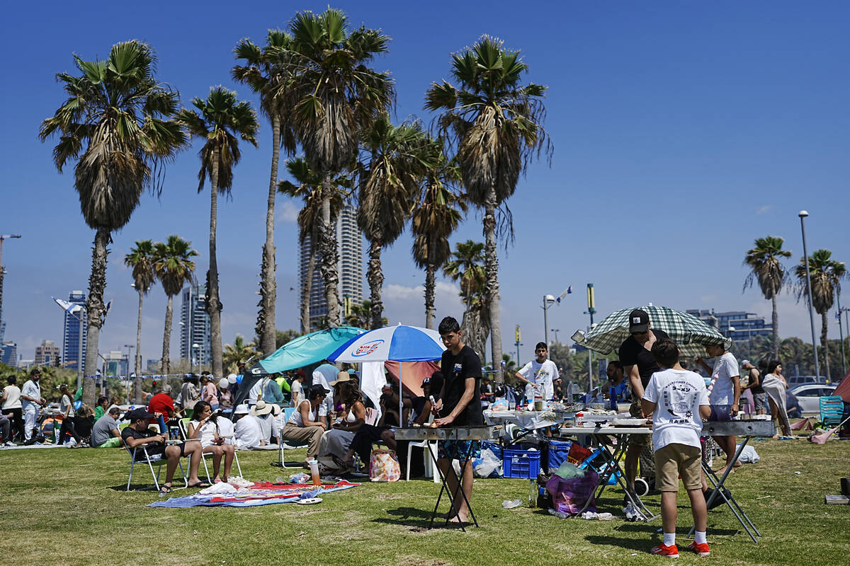 People prepare their food on a grill as they spend the day on a park during Israel's Independen ...