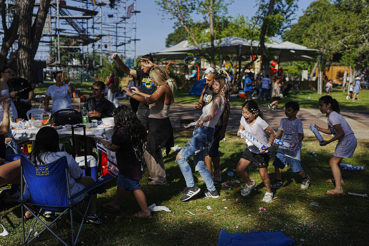 Children joke around as they spend the day during Israel's Independence Day celebrations, at a ...