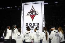 The Las Vegas Aces watch as a banner is hung to honor their 2023 WNBA Championship win before a ...