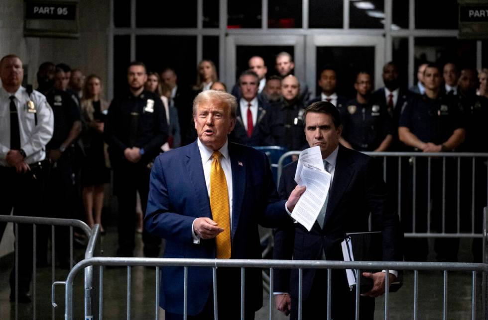 Former President Donald Trump, standing with defense attorney Todd Blanche, speaks after a cour ...