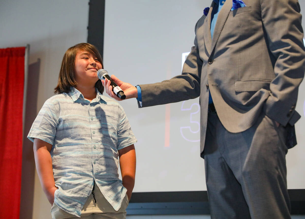 Chet Buchanan, professional radio and television host, asks a question of third grade winner Br ...