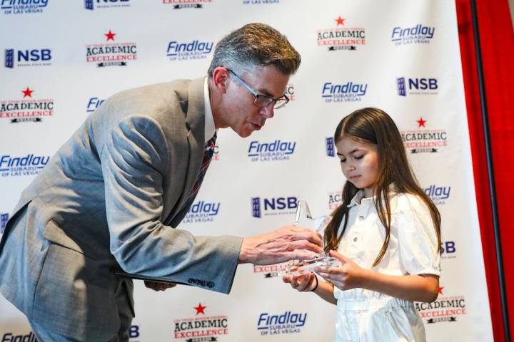 Review-Journal’s Executive Editor Glenn Cook hands a trophy to first grade winner Lucy Pavlid ...