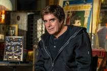 David Copperfield sits with his new book, "History of Magic, within his magic museum on Wednesd ...