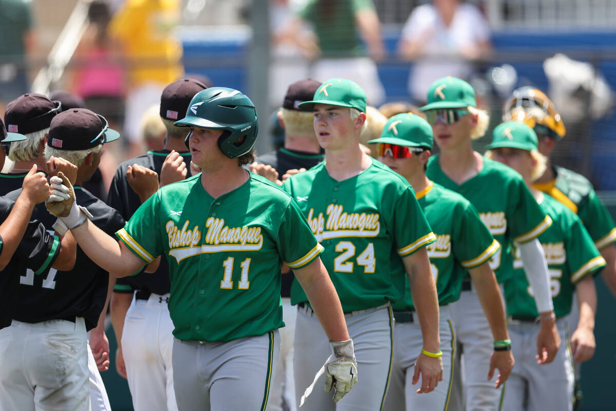 Bishop Manogue first baseman Holden Rowan (11) leads a line of players as they congratulate Pal ...