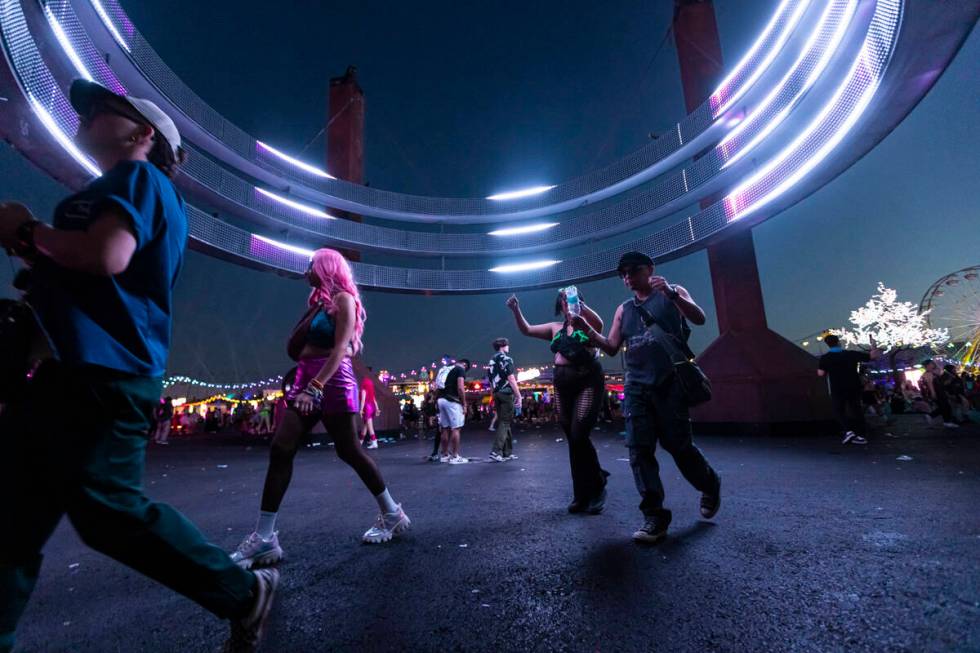 Festival attendees walk by as the sun begins to rise during the second night of the Electric Da ...