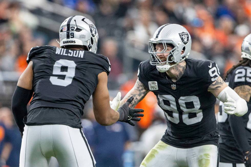 Raiders defensive end Maxx Crosby (98) congratulates defensive end Tyree Wilson (9) on his sack ...