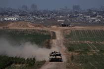 Israeli soldiers move on the top of a tank near the Israeli-Gaza border, as seen from southern ...