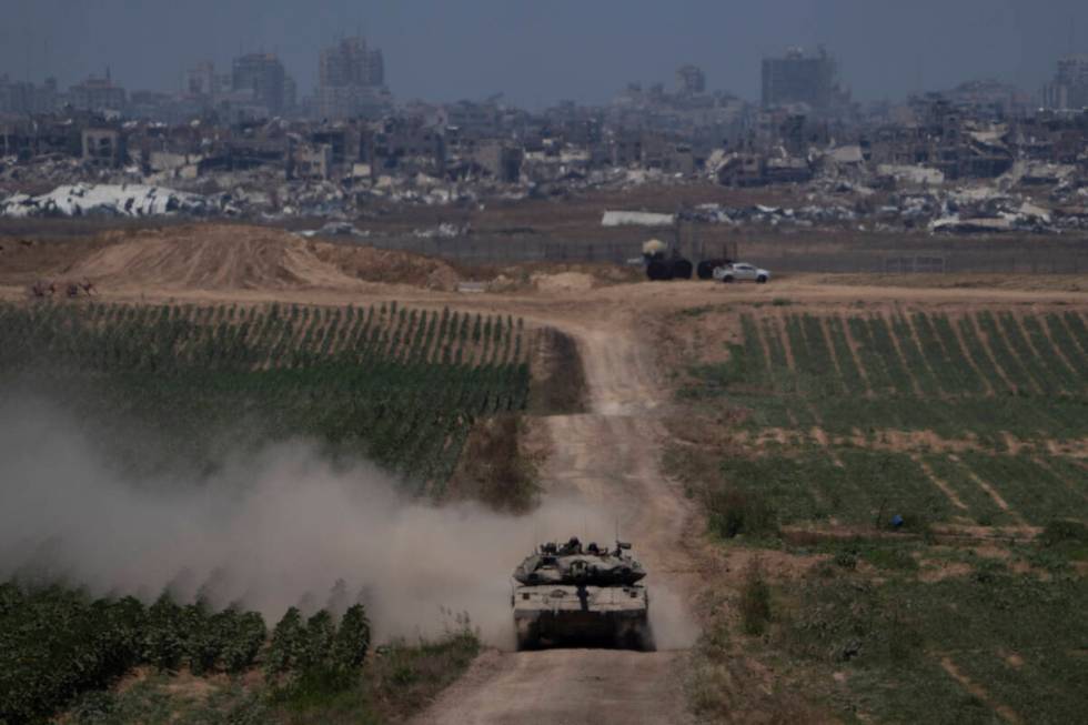 Israeli soldiers move on the top of a tank near the Israeli-Gaza border, as seen from southern ...