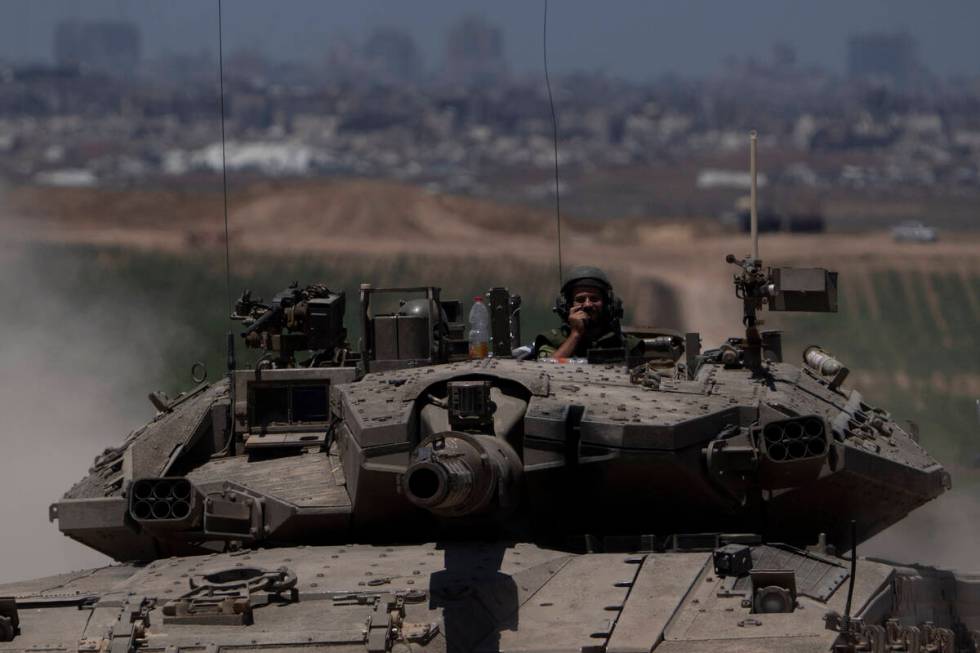 Israeli soldiers move on the top of a tank near the Israeli-Gaza border, as seen from southern ...