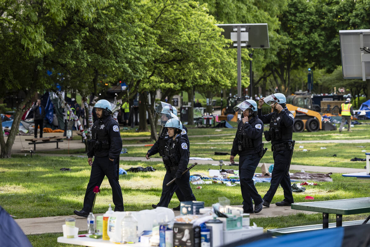Chicago police officers walk through the quad as crews disassemble the pro-Palestinian protest ...
