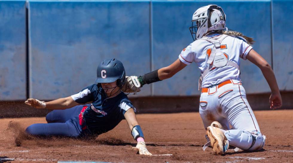 Coronado runner Alohi Mundon (8) attempts a score at home plate over Douglas catcher Peyton Sim ...